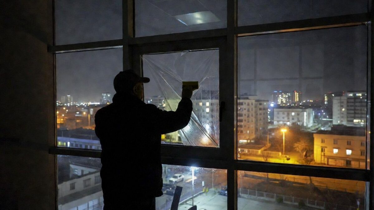 person-installing-window-film-at-night
