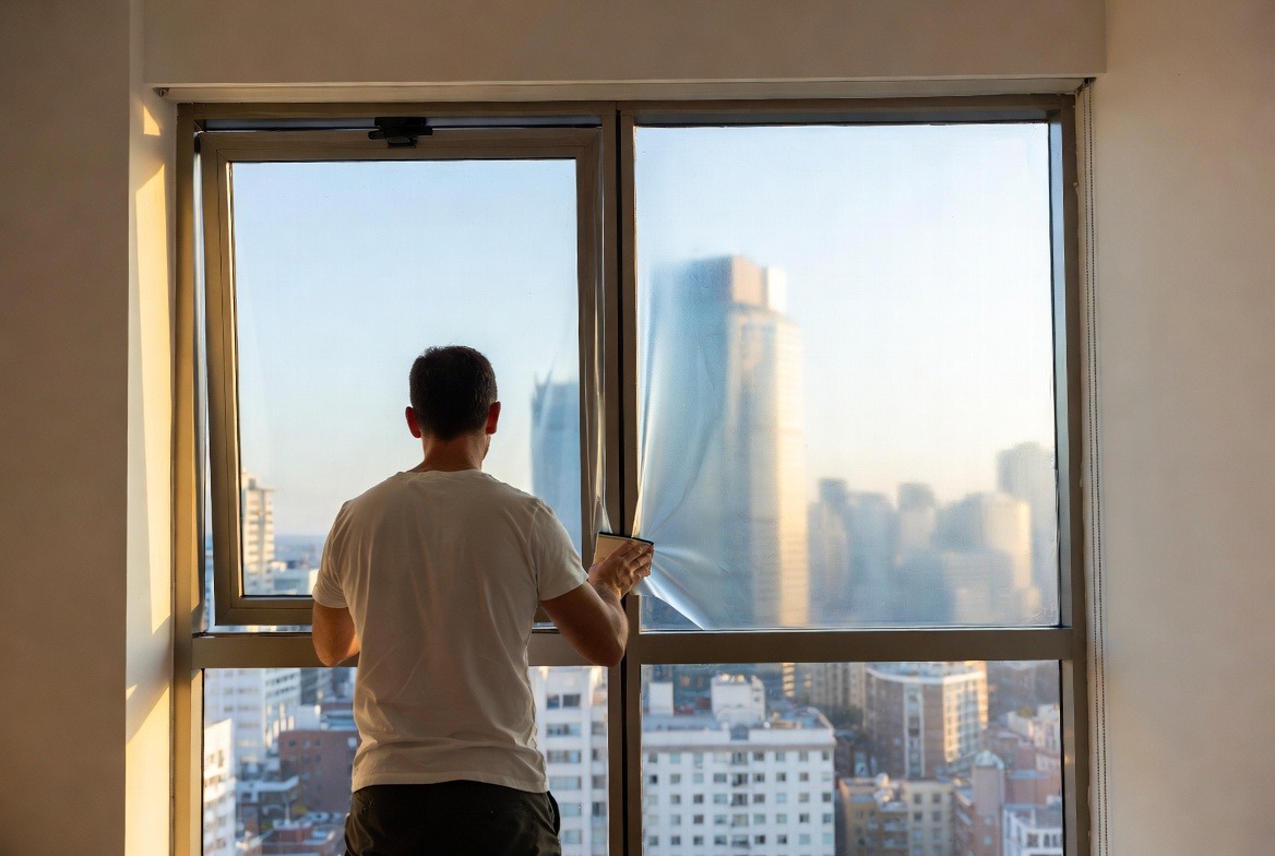 person-installing-window-film-on-glass